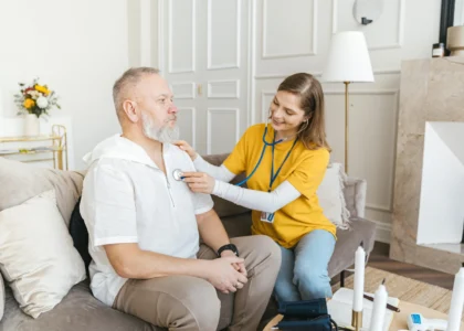 Healthcare professional examining male patient in home setting, emphasizing personalized wound care and support services.