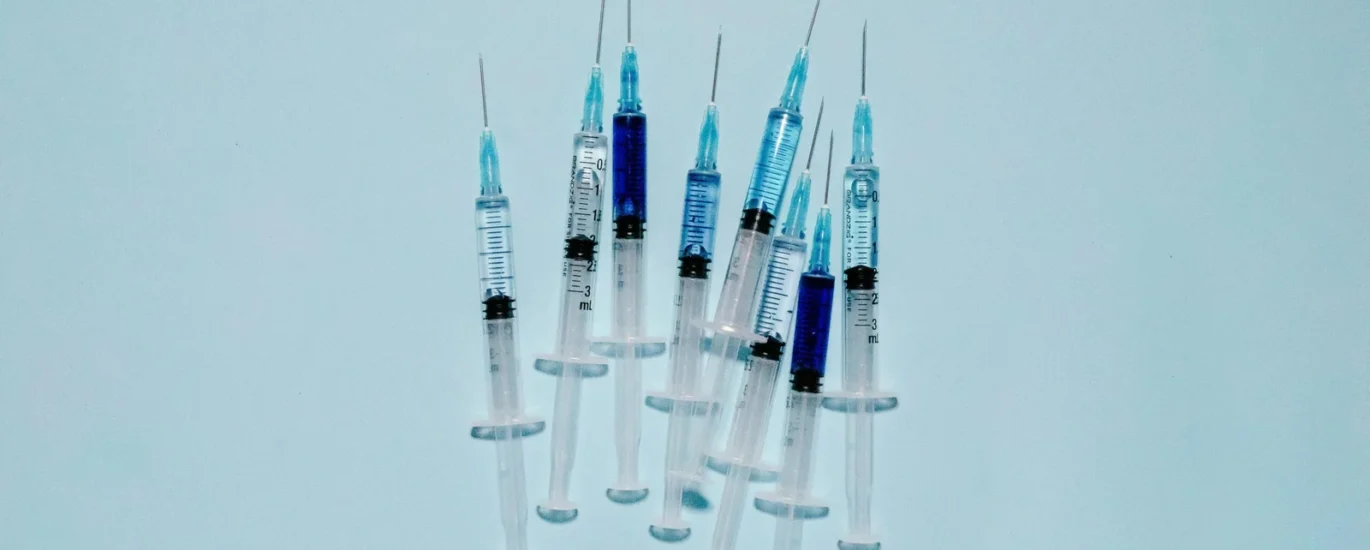 Syringes with blue liquid, representing advanced wound care treatments and regenerative medicine solutions for chronic wounds.