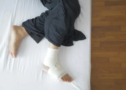 Person with a bandaged foot resting on a bed, illustrating wound care for diabetic foot ulcers and chronic wounds.