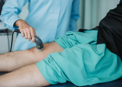 Medical professional using ultrasound therapy on a patient's leg, focusing on chronic venous insufficiency treatment.